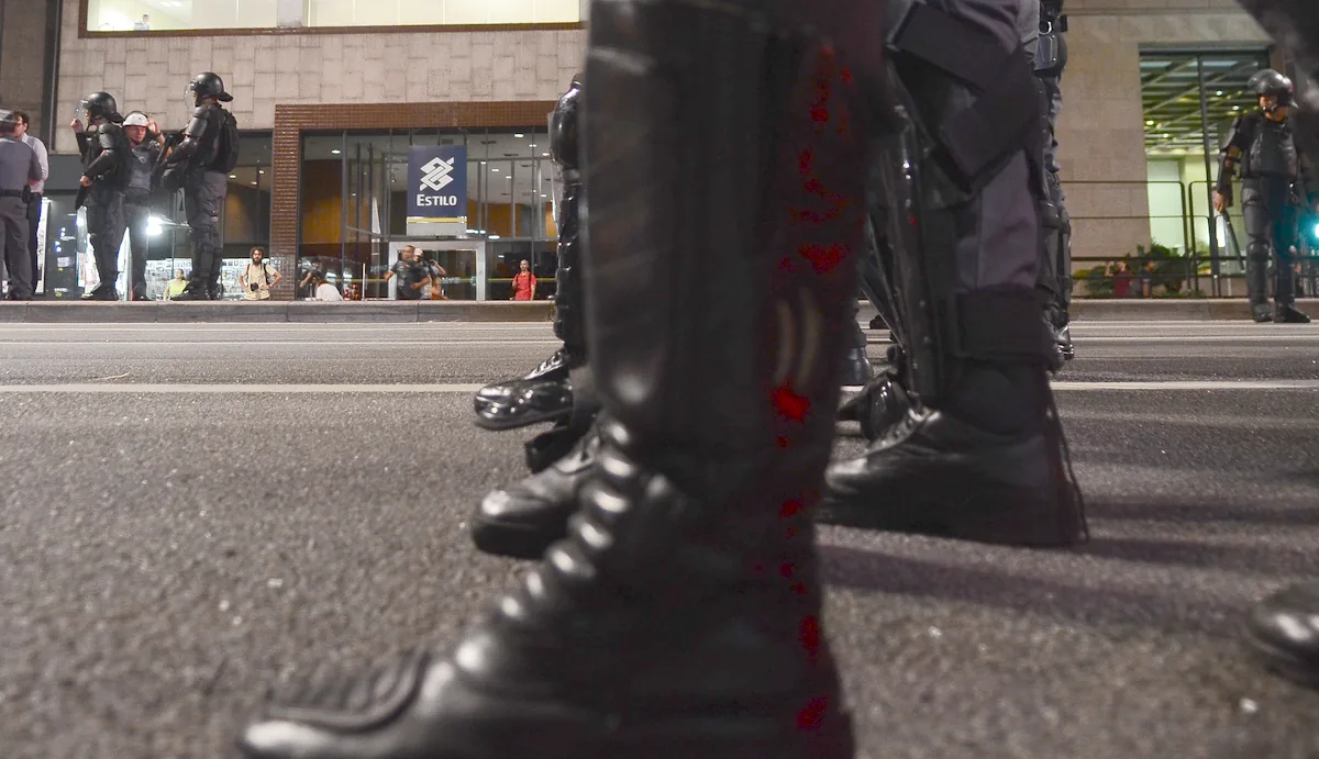 Botas de policiais militares em primeiro plano, vistas do nível do asfalto, durante manifestação na Avenida Paulista