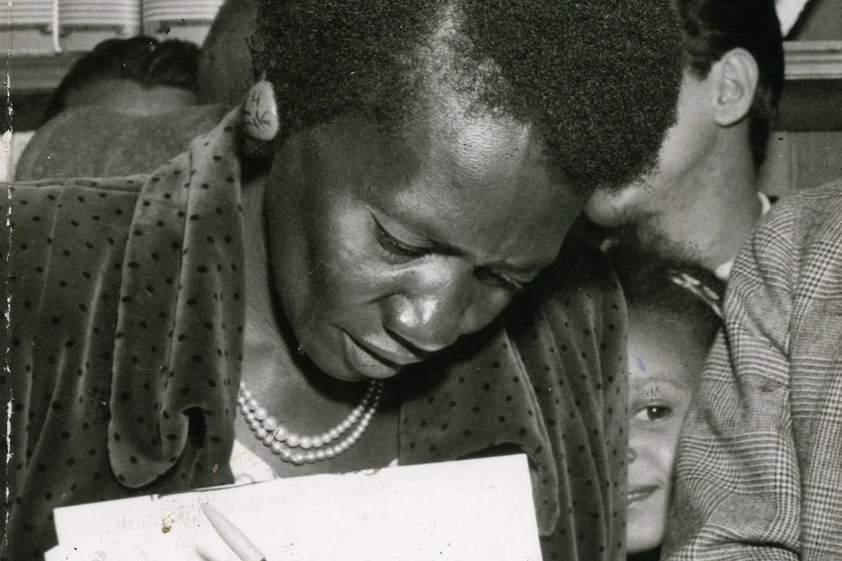 Carolina Maria de Jesus autografa exemplares de Quarto de Despejo em 1960, cercada de leitores