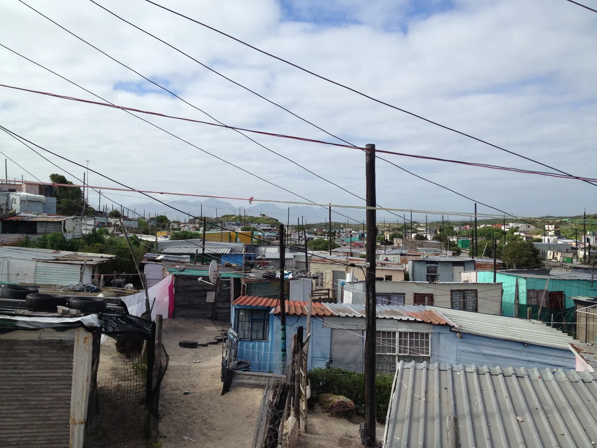 Casas baixas e fios de energia cruzando o c&eacute;u em Gugulethu, na Cidade do Cabo