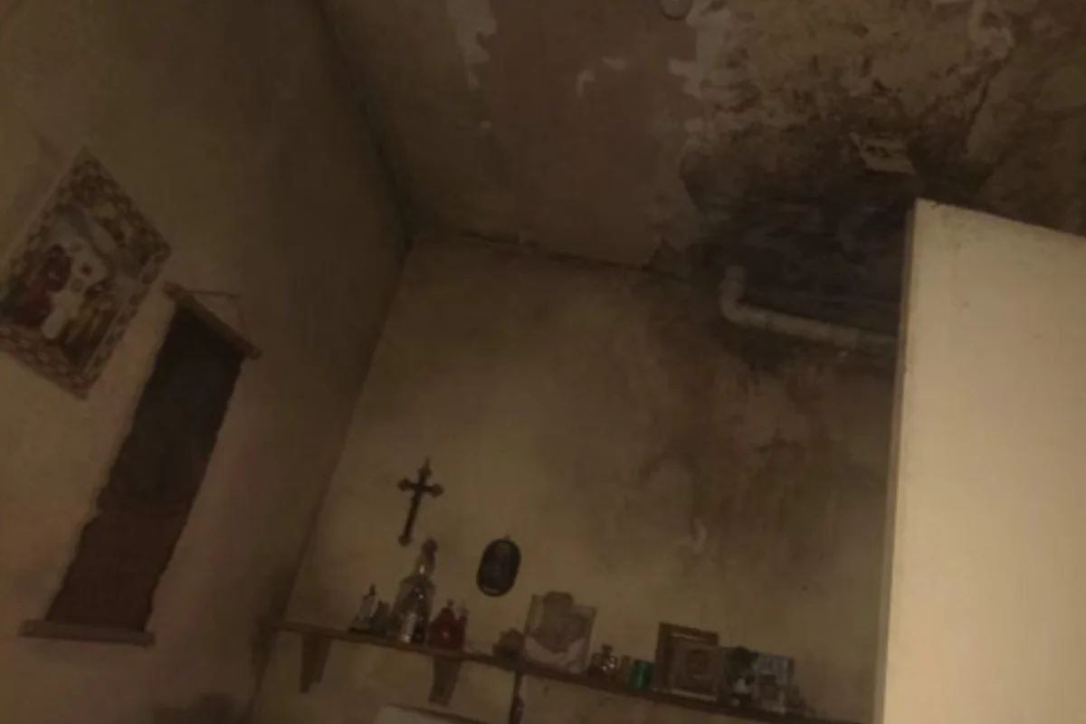 Quarto com paredes mofadas e uma prateleira com crucifixo e imagens de santos, na casa de Belo Horizonte onde as trabalhadoras foram resgatadas