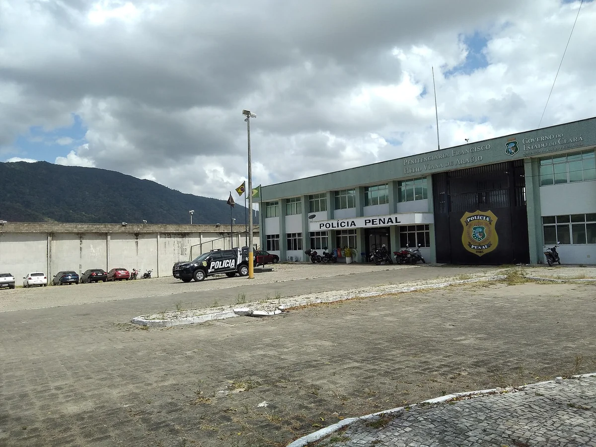 Fachada da Penitenciária Francisco Hélio Viana de Araújo, em Pacatuba, no Ceará, com viatura da Polícia Penal estacionada
