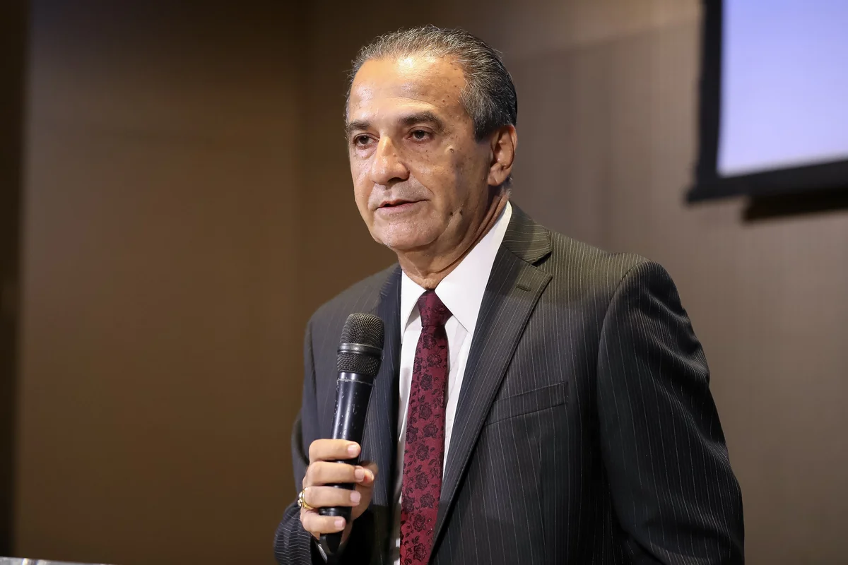 O pastor Silas Malafaia fala ao microfone, de terno escuro e gravata vinho