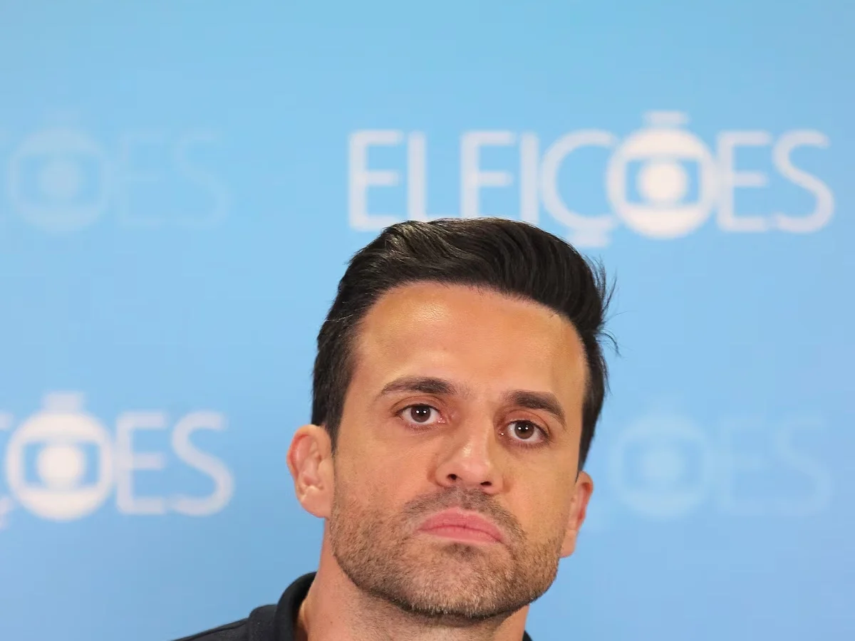 Pablo Marçal, de camisa preta, diante de um painel com a marca Eleições