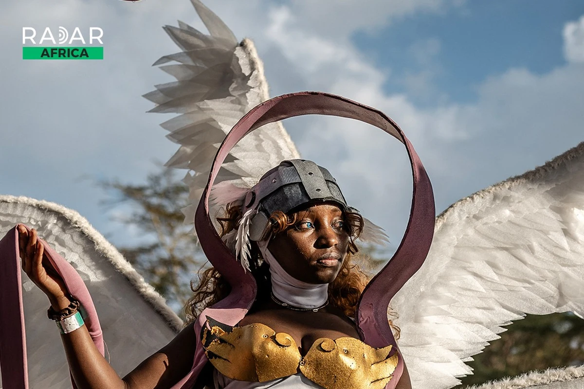 Cosplayer queniana com asas brancas e armadura dourada feitas à mão, na convenção Otamatsuri, em Nairóbi