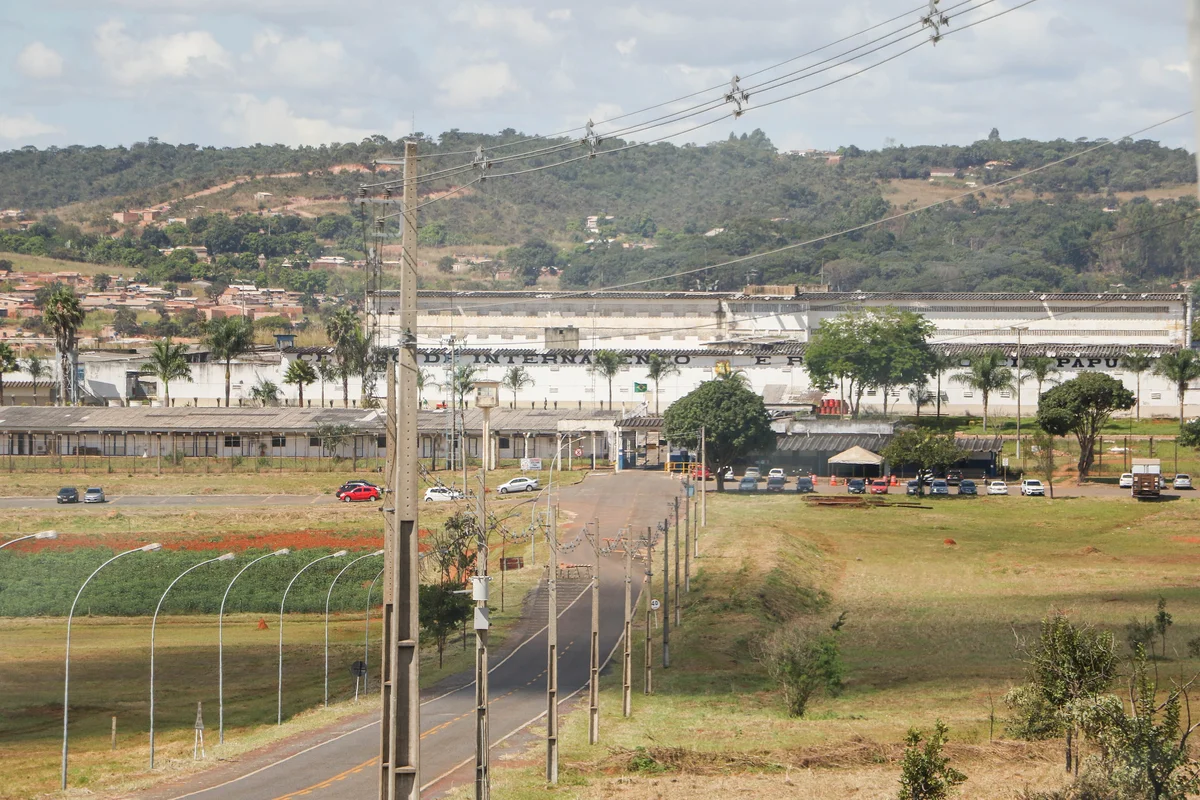 Vista aérea do Complexo Penitenciário da Papuda, com prédios baixos, estrada e morros ao fundo
