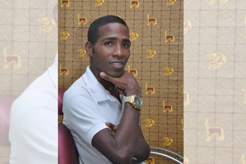 Valdir Macário, de camisa polo branca, sentado com a mão apoiada no queixo